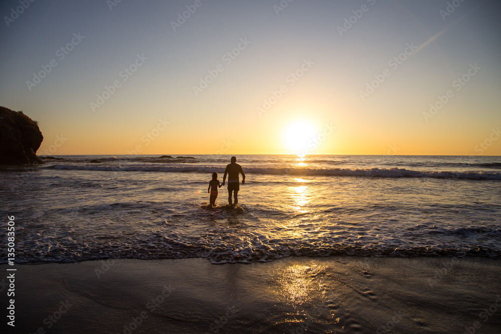 Father and daughter hand by hand bathing in the water