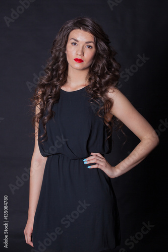 young and beautiful brunette on black fonev black dress