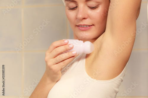 Woman applying stick deodorant in armpit