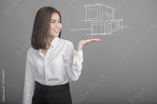Beautiful Business Woman presenting real estate a model of the h