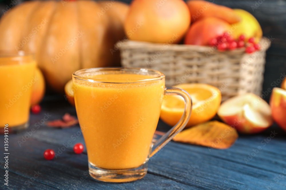 Glass of pumpkin smoothie on wooden background