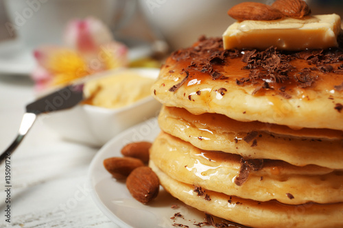 Stack of fresh pancakes with nuts on plate