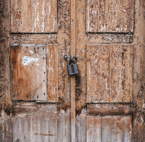Old weathered grunge rusty locked padlock old wooden board door