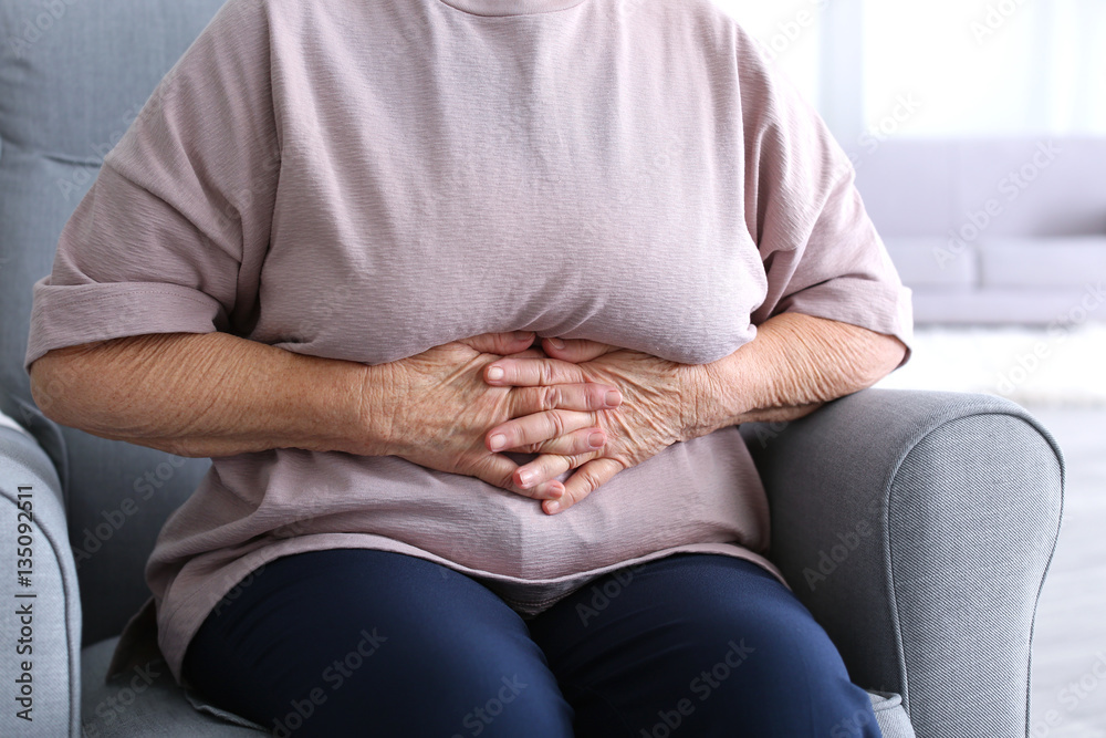 Elderly woman suffering from stomach ache at home, closeup Elderly woman suffering from stomach ache at home, closeup