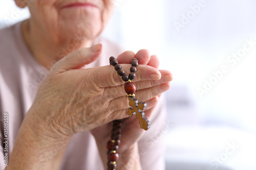Elderly woman with rosary b...