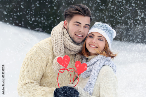 Young couple with hearts in...