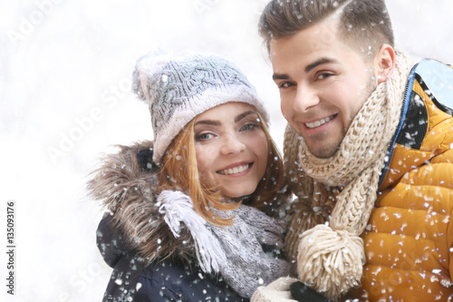 Young couple in snowfall ou...
