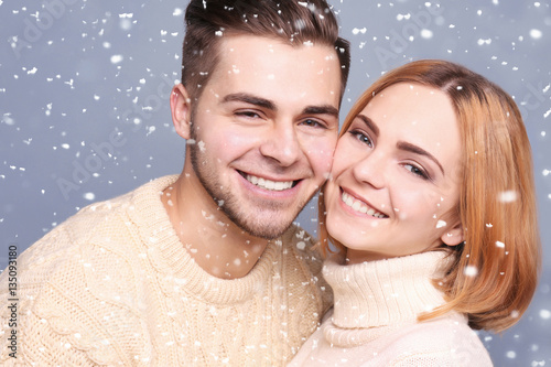 Young couple posing on gray...