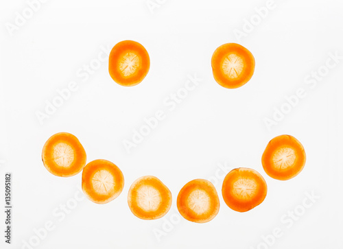 Backlit slices of carrot in smiley shape, abstract textured background
