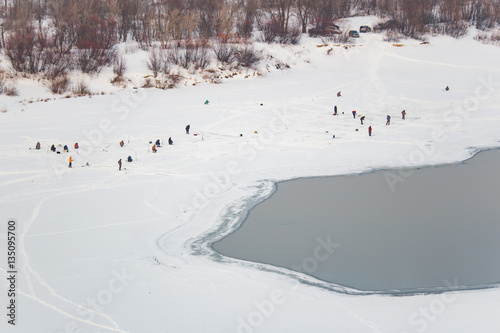 Lot of people fishing on the ice in winter