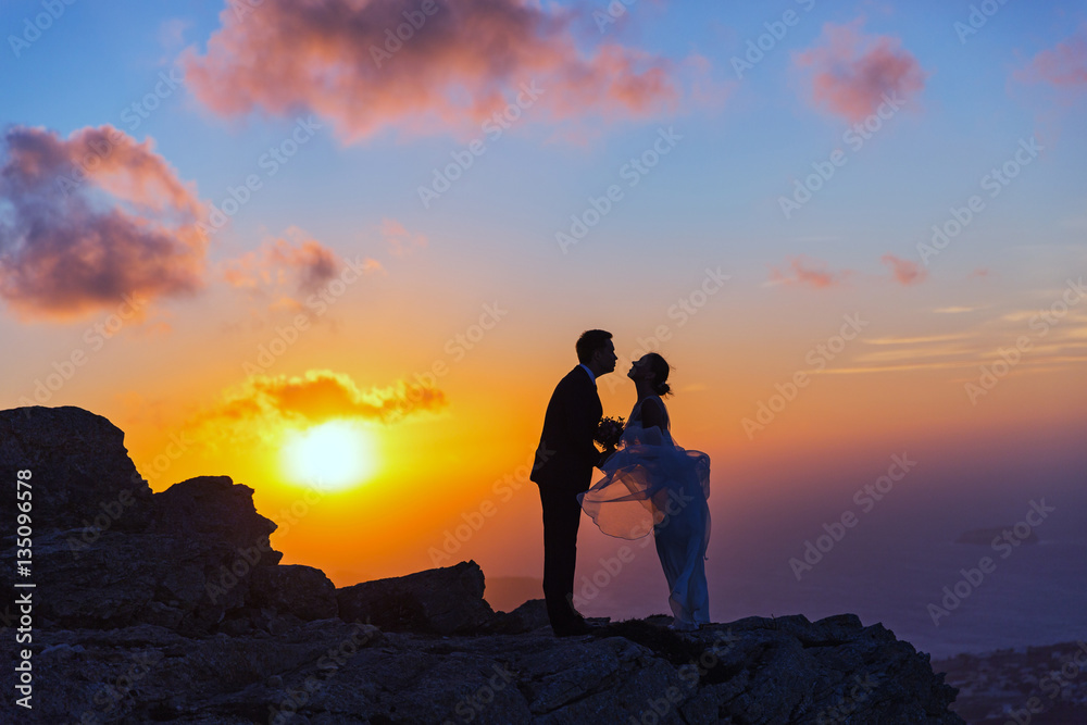 Silhouette of bride and groom on the  sea sunset