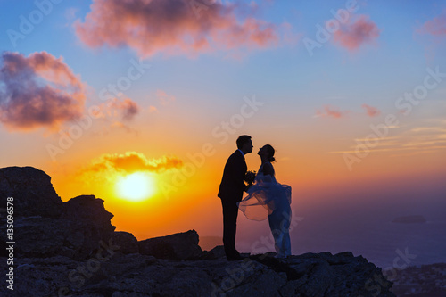 Silhouette of bride and groom on the  sea sunset