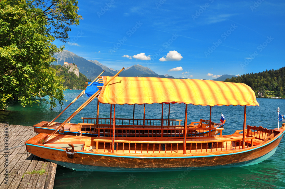 Traditional Pletna boat on the lake. In the background is the famous old castle on the cliff.Bled lake Slovenia,Europe 