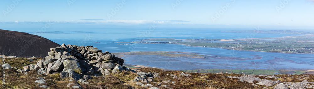 Stone shelter on the mountains of the Dingle Peninsula overlooks Fenit and Tralee Bay along the Wild Atlantic Way in County Kerry, Ireland