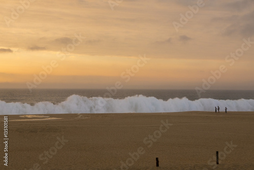 Sunset on beach near Espichel Cape with massive ocean waves in P