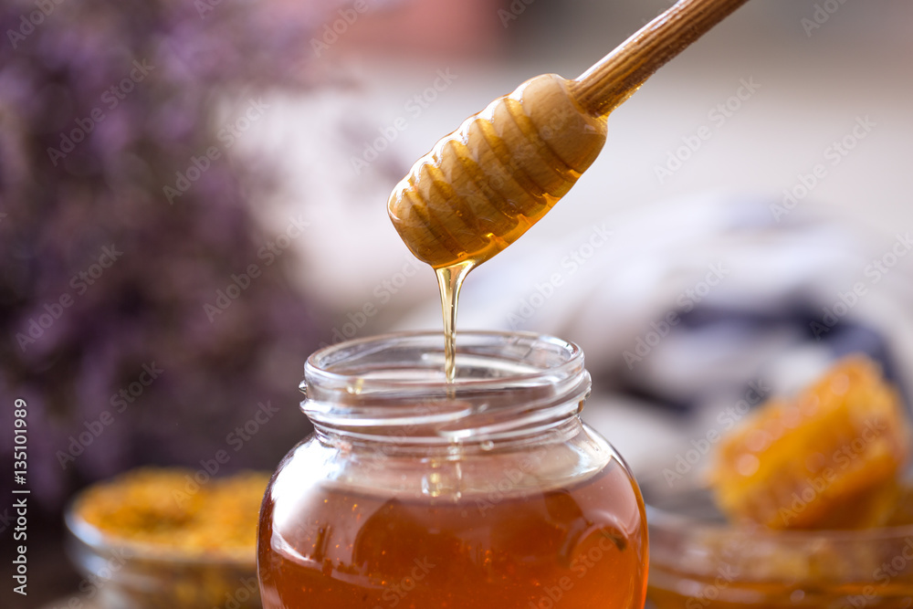 dripping sweet fresh honey from wooden dipper. dripping sweet fresh honey from wooden dipper.