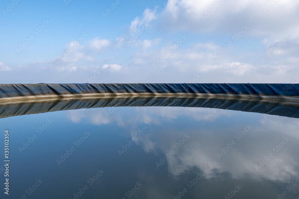 Swimming pool and clouse reflections in the water, Spain