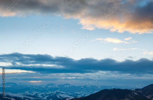 Beautiful winter mountain landscape at sunset with blue sky and dramatic clouds © ihor_b