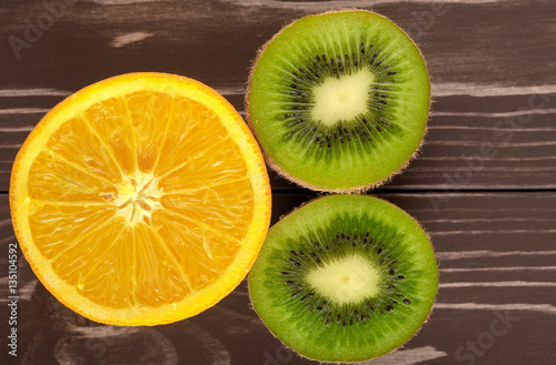 orange and kiwi on a wooden brown background