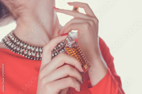 Woman applying perfume on her neck