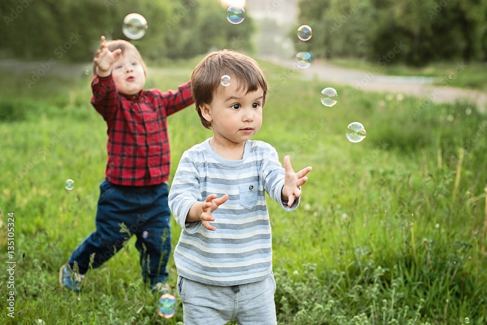 One years old caucasian child boys blowing soap bubbles outdoor One years old caucasian child boys blowing soap bubbles outdoor
