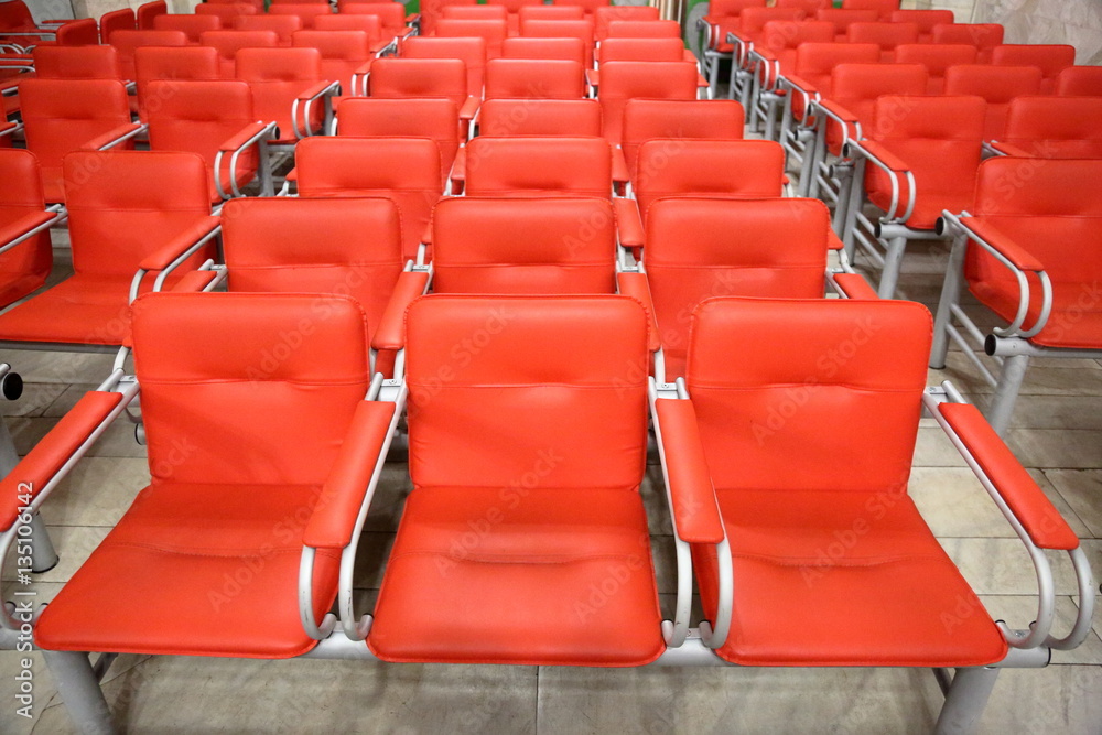 Armchairs with metal frame and red leather upholstery in a row Armchairs with metal frame and red leather upholstery in a row