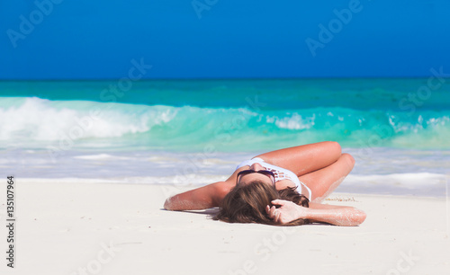 portrait of woman in bikini relaxing on tropical beach