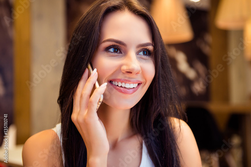Portrait of beautiful woman with beaming smile talking on phone