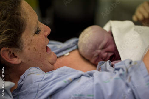 Freshly born baby skin to skin on mothers chest caucasian female