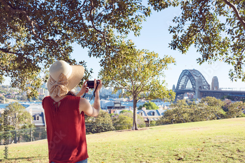 Photography Woman in summer hat taking pictures of Sydney Harbour