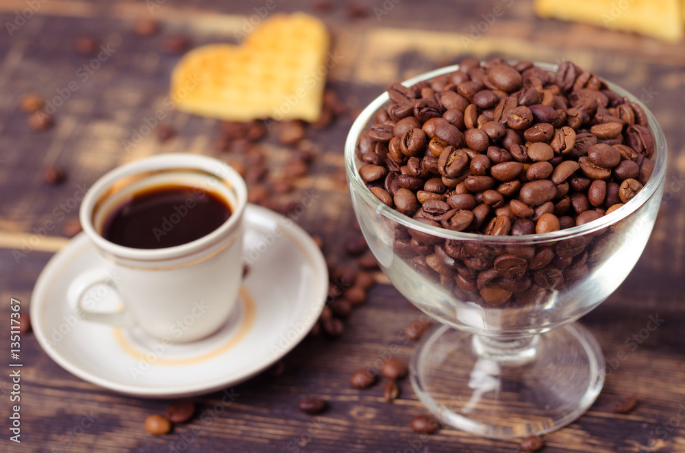 White coffee cup and coffee beans on old wooden background. White coffee cup and coffee beans on old wooden background.