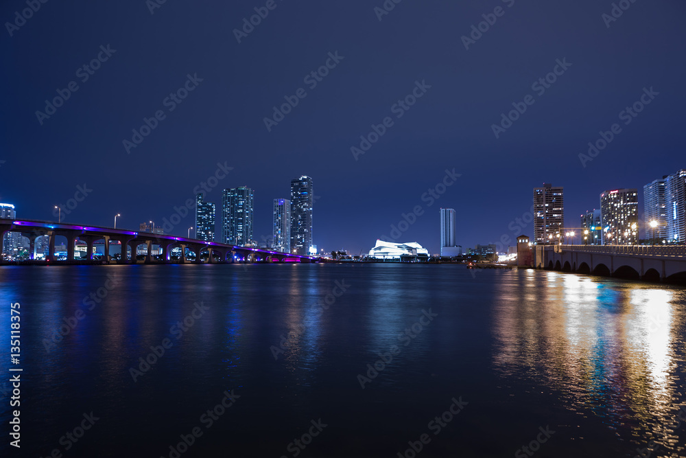 View on Miami Downtown and MacArthur Causeway at night time with a view on a bay, Sunset. USA