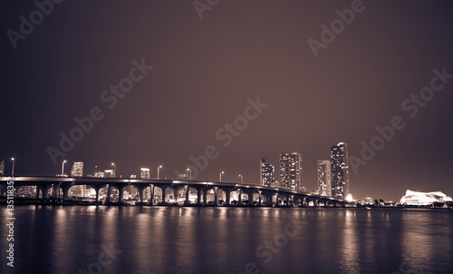 View on Miami Downtown and MacArthur Causeway at night time with a view on a bay, USA greyscale