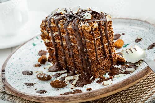 Piece of chocolate Spartak cake on a table. Delicious sweet food on a beautiful plate. Close-up shot. photo