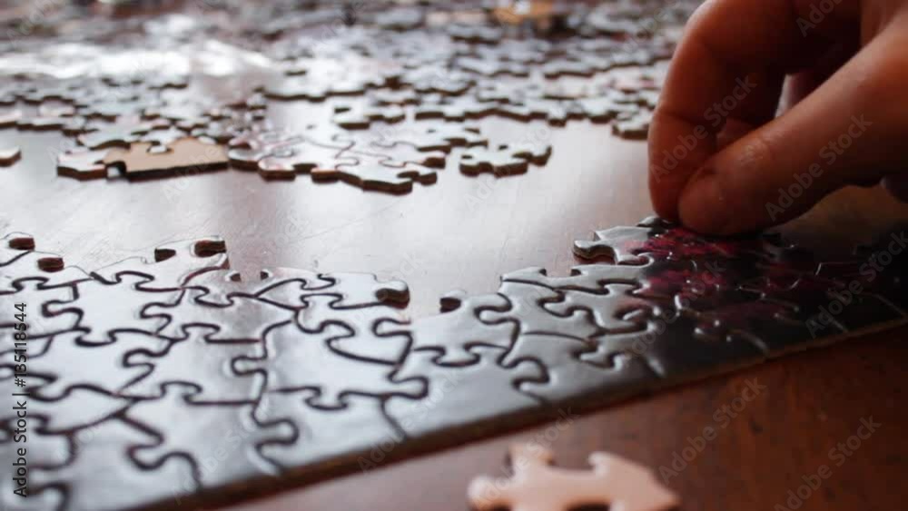 Hand successfully inserts correct puzzle piece into complex puzzle Hand successfully inserts correct puzzle piece into complex puzzle