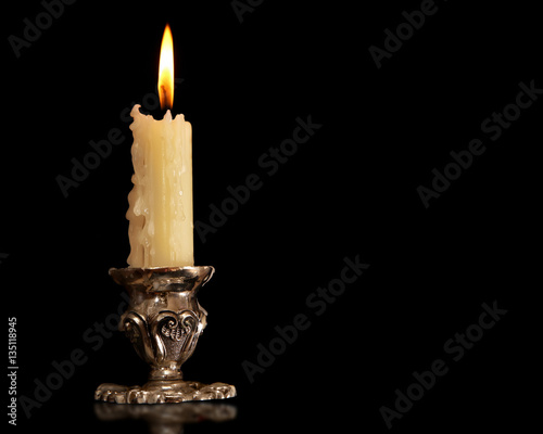 Bild auf Leinwand burning old candle vintage Silver bronze candlestick