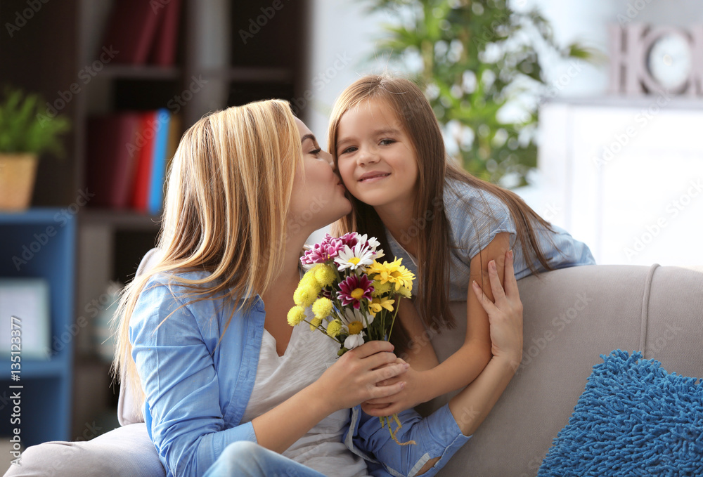 Little girl giving bouquet of beautiful flowers to her mother. Mother's day concept Little girl giving bouquet of beautiful flowers to her mother. Mother's day concept