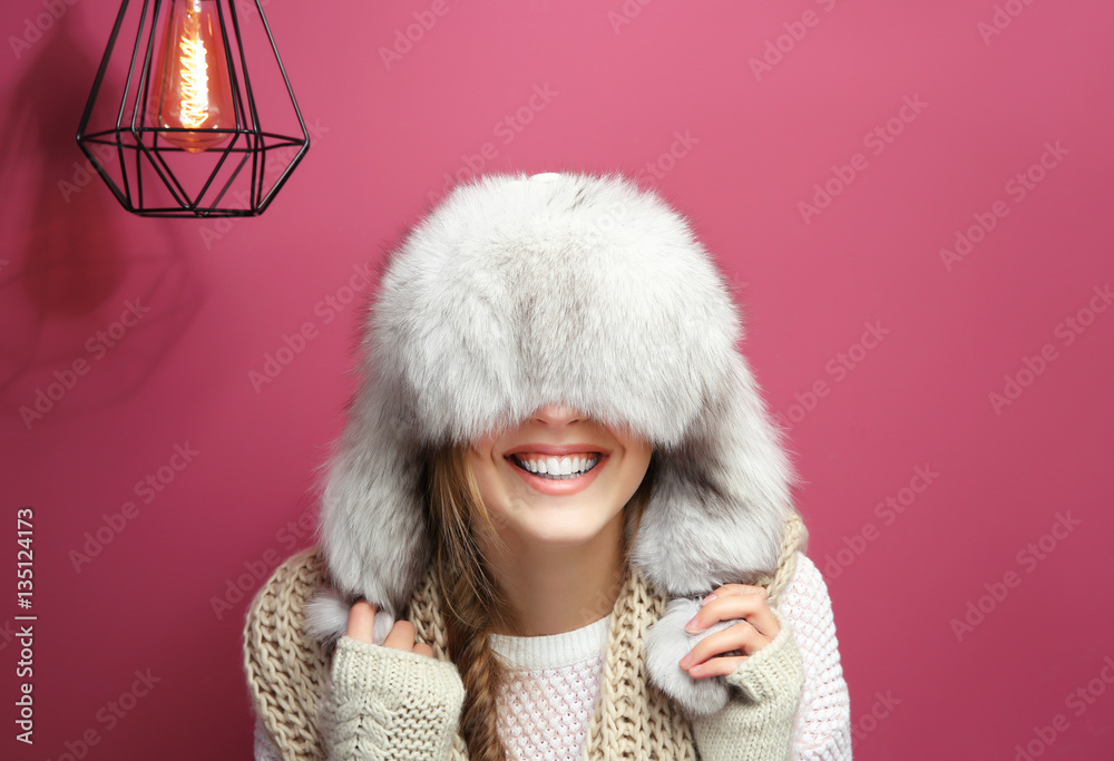 Funny young woman in warm clothes on color background Funny young woman in warm clothes on color background