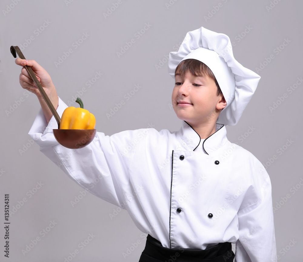 Cute boy in chef uniform on light background Cute boy in chef uniform on light background
