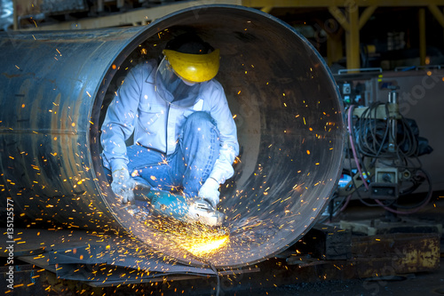 Surface preparation on pipe construction by hand grinding tool photo