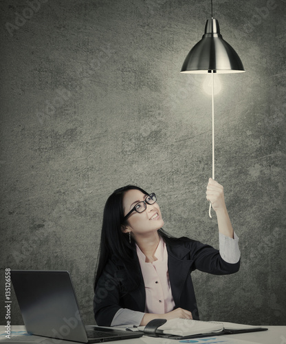 Obraz na plátně Businesswoman switching on idea light bulb