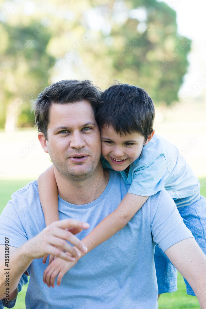 Portrait joyful father and son in park outdoors Portrait joyful father and son in park outdoors