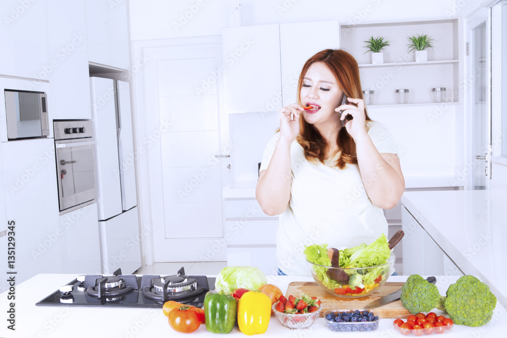 Obese woman with salad and mobile phone