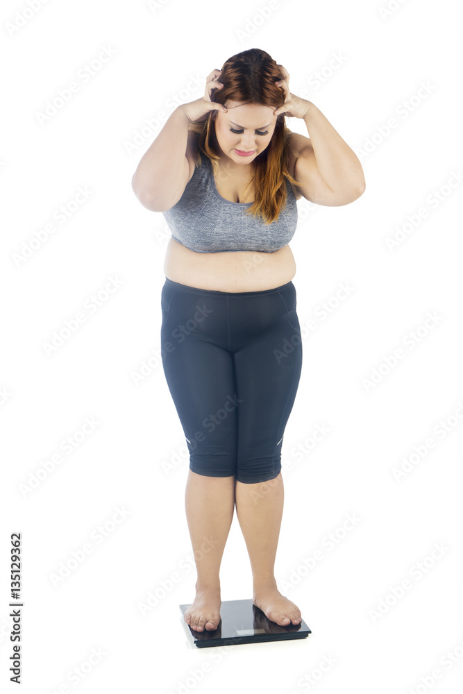 Overweight woman shocked with weight scale Overweight woman shocked with weight scale