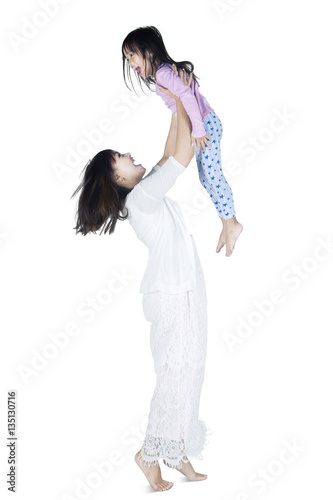 Young mother lift up her daughter