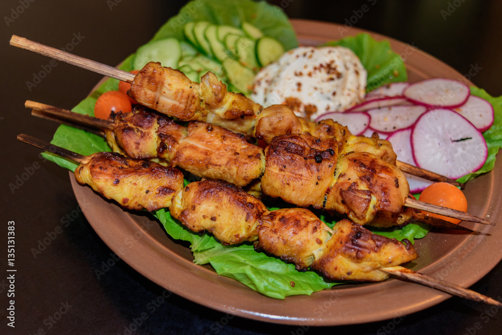 Chicken kebab with vegetables on a clay plate Chicken kebab with vegetables on a clay plate