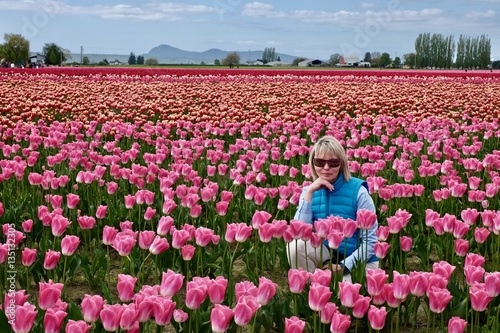 Beautiful blond woman in colorful tulip fields. Mount Vernon Tulip Festival. Tulip Town. Seattle. Burlington. Washington. United States. 
