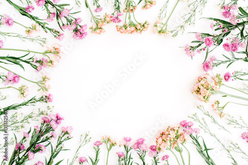 Round frame of colorful wildflowers, green leaves, branches on white background. Flat lay, top view. Valentine's background © Floral Deco