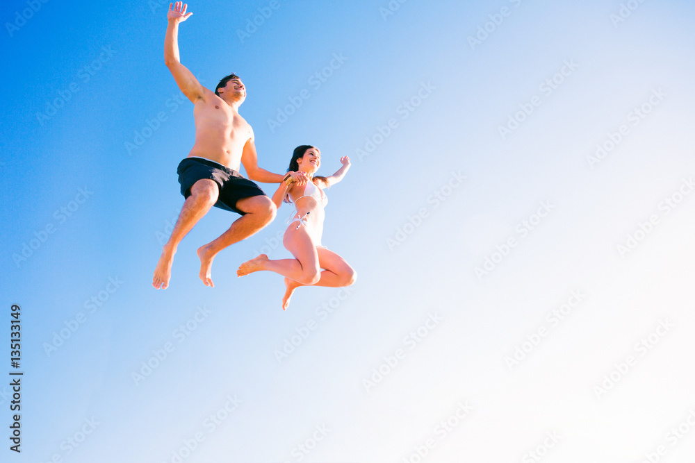 Young Couple In Swimwear Jumping