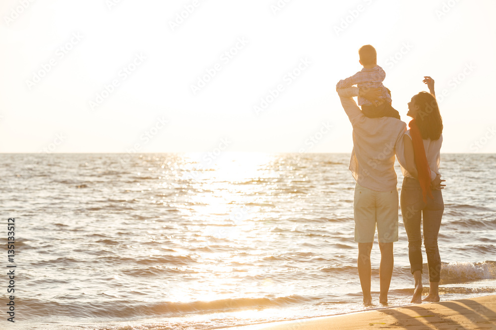 Fototapeta premium happy young family have fun on beach run and jump at sunset
